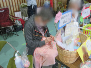 売り子をしながら編み物をする入居者さん